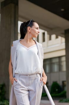 Happy businesswoman smiling while standing in suit on city street