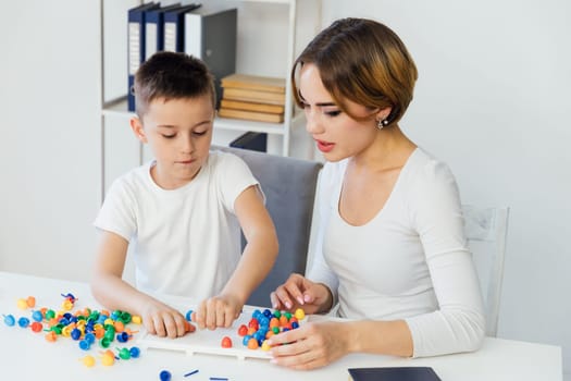 Teacher playing educational games with little boy at school
