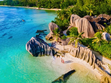 Anse Source d'Argent beach, La Digue Island, Seychelles, Drone aerial view of La Digue Seychelles bird eye view of tropical Island, men and woman at the beach during sunset at a luxury vacation