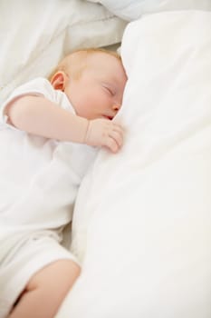 Sleeping, bed and baby with pillow in home for dreaming, resting and nap for child development. Family, nursery and comfortable newborn infant in bedroom relax for wellness, health and growth.