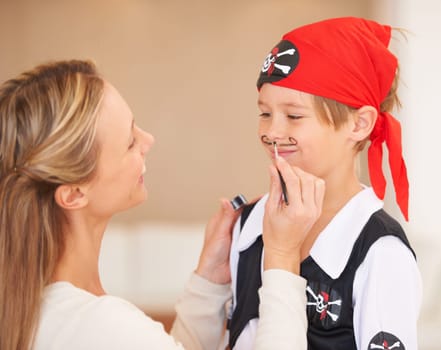 Boy, pirate costume and halloween in home, woman and face paint for happiness in childhood. Son, smile and mother with party make up, love family and bonding together with care celebration in house.