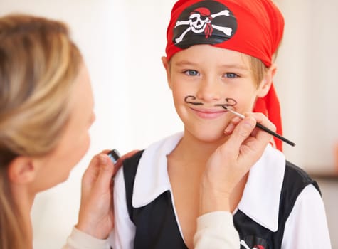 Boy, portrait or pirate face paint with woman, halloween or holiday happiness in childhood in home. Child, mother and theme make up for vacation, clothes and love care for party celebration in house.