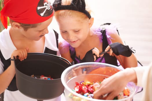Siblings, trick o treat and halloween costume outdoor, sweets and happiness in community. Boy, girl or smile face for holiday with candy bucket, collect chocolates and fairy or pirate by neighbours.