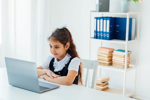 girl sitting at desk with laptop at school