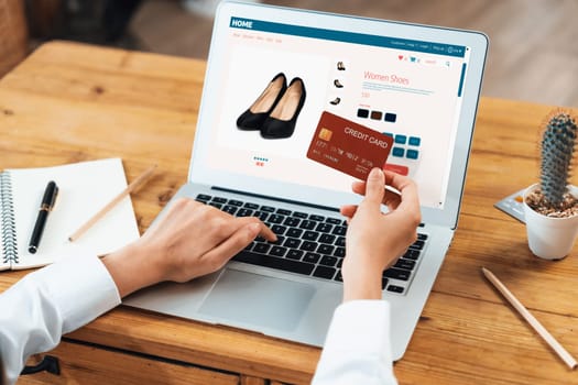 Woman shopping online on internet marketplace browsing for sale items for modern lifestyle and use credit card for online payment from wallet protected by uttermost cyber security software