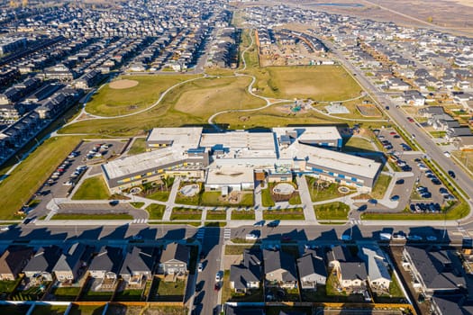 Aerial image of Evergreen, Saskatoon, SK, highlighting tree-lined streets, modern homes, and green spaces. A serene neighborhood portrait, ideal for real estate and urban planning.