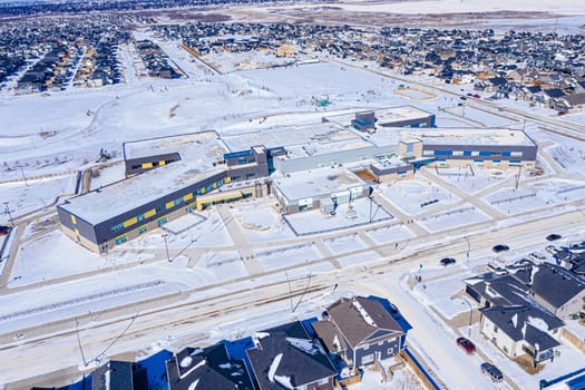 Aerial image of Evergreen, Saskatoon, SK, highlighting tree-lined streets, modern homes, and green spaces. A serene neighborhood portrait, ideal for real estate and urban planning.