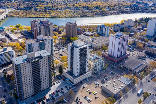 Experience the vibrant summer life of Downtown Saskatoon from above. This drone image captures the bustling streets, lush riverbanks, and lively urban atmosphere during the city's warmest months.