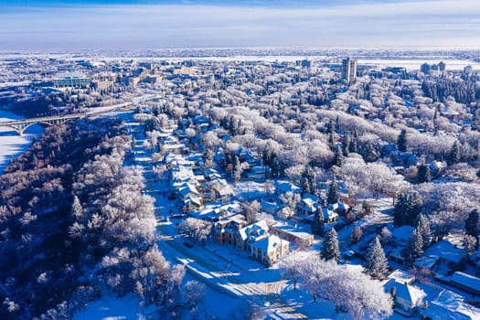 Behold the winter wonderland of Downtown Saskatoon from the sky. This drone image captures the snowy cityscape, frozen river views, and the serene beauty of urban life in the chill of winter.