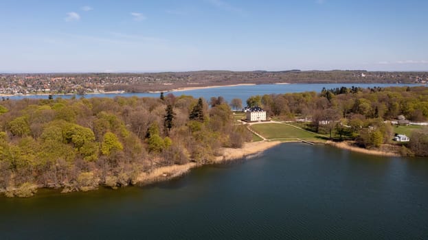 Holte, Denmark - April 26, 2022: Aerial drown view of Naesse Castle located at Lake Furesoe