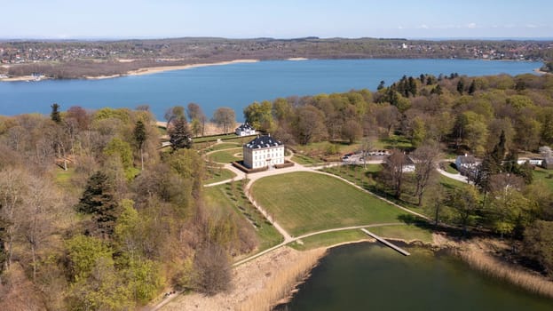 Holte, Denmark - April 26, 2022: Aerial drown view of Naesse Castle located at Lake Furesoe