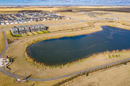 Discover Kensington in Saskatoon from a bird's-eye view. This drone image highlights the neighborhood's modern architecture, green spaces, and the lively, community-focused atmosphere.