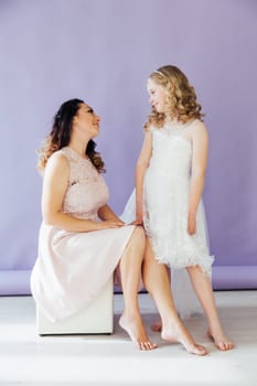 Mom and daughter in dresses hold hands