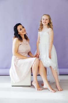 Mom and daughter in dresses hold hands
