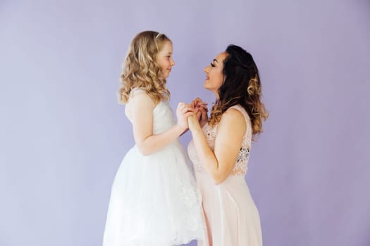 Mom and daughter in dresses hold hands