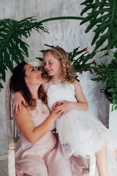 Mom and daughter in dresses hold hands