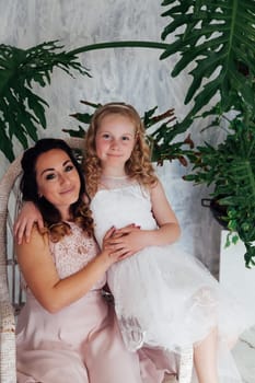 Mom and daughter in dresses hold hands