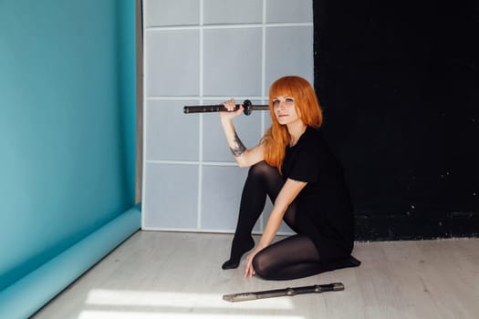 Woman cosplayer with red hair holds a Japanese sword