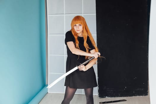 Woman cosplayer with red hair holds a Japanese sword