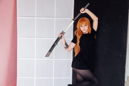 cosplayer anime with red hair holds a Japanese sword