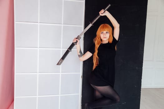 cosplayer anime with red hair holds a Japanese sword