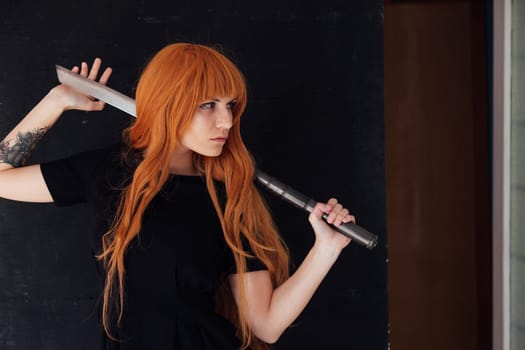 cosplayer anime with red hair holds a Japanese sword