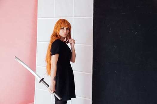 cosplayer with red hair holds Japanese sword