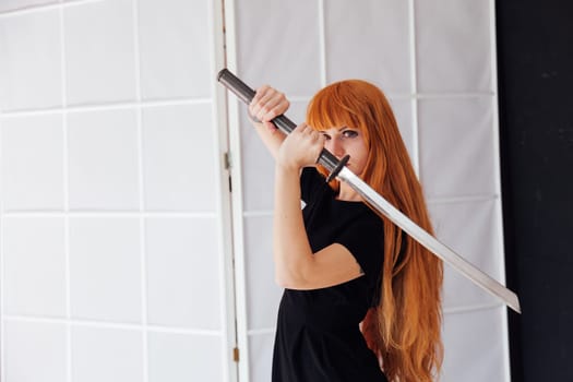 cosplayer with red hair holds Japanese sword