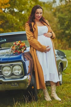 Vejle, Denmark, October 26, 2023: Pregnant woman near a retro car.