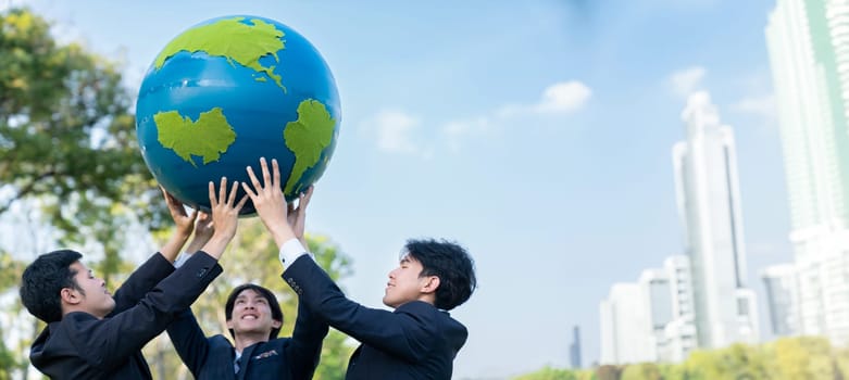 Earth day concept with big Earth globe held by group of asian business people team promoting environmental awareness with environmentally sustainability and ESG principle for brighter future. Gyre