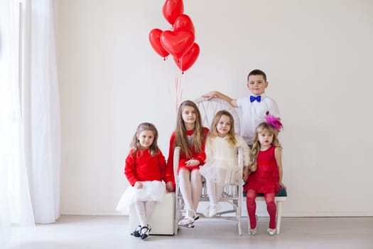 four girls in a white room with red holiday balloons and a boy