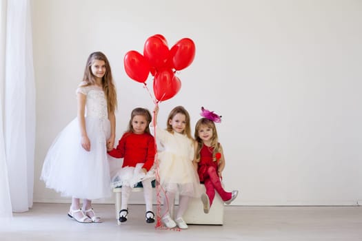 four girls in a room with red balloons