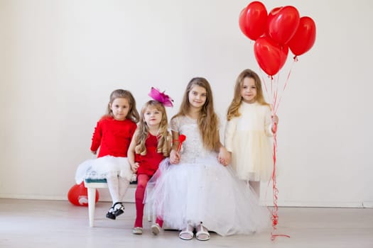 four girls in a room with red balloons