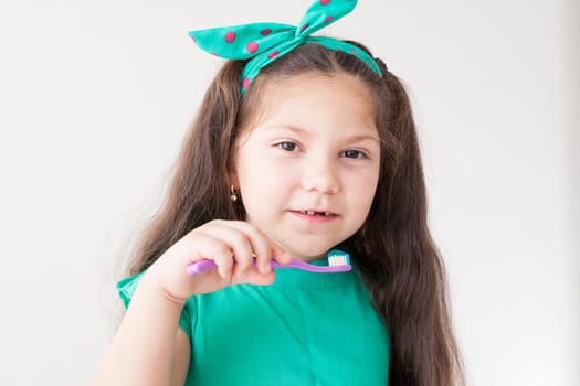 Beautiful little girl brushes her teeth with a toothbrush