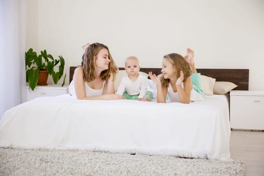 three girls sisters of different ages in the morning in the bedroom without parents