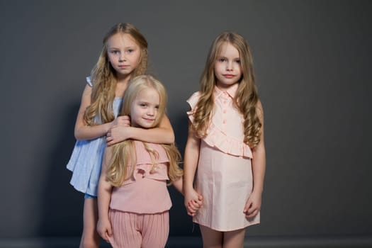 three fashionable girls in light dresses