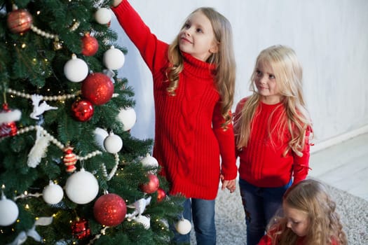 Three little girl girlfriends open Christmas presents to the new year