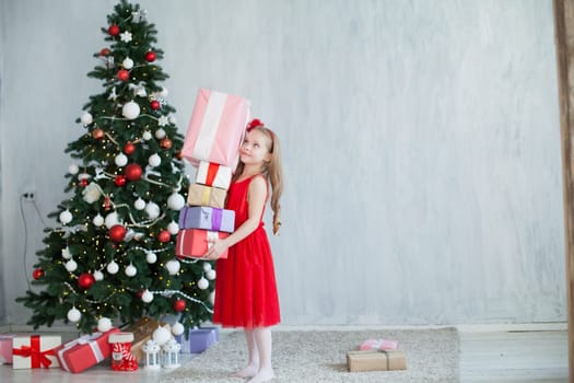 girl decorates Christmas tree gifts new year