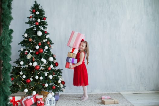 girl decorates Christmas tree gifts new year