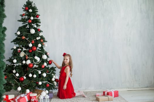 girl decorates Christmas tree gifts new year