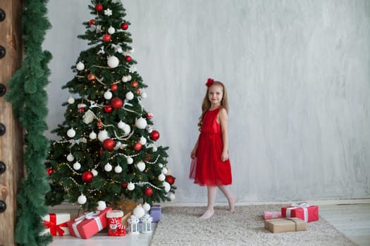 girl decorates Christmas tree gifts new year