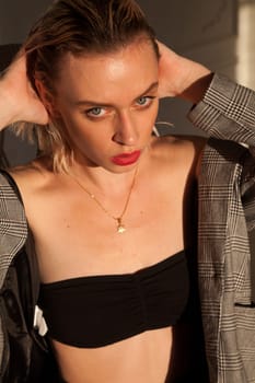 Portrait of a blonde woman sitting in a chair in an empty room