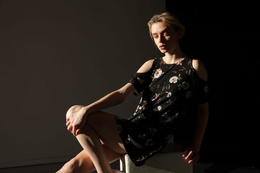 Portrait of a blonde woman in a black dress with flowers