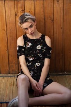 Portrait of a blonde woman in a black dress with flowers