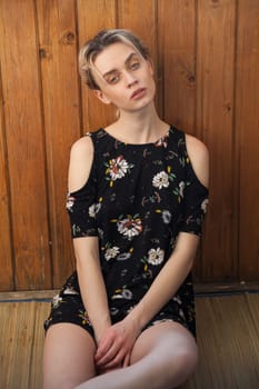 Portrait of a blonde woman in a black dress with flowers