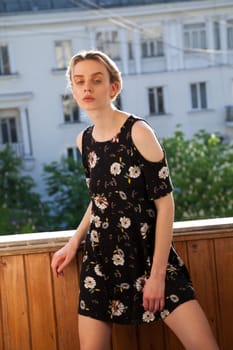 Portrait of a blonde woman in a black dress with flowers