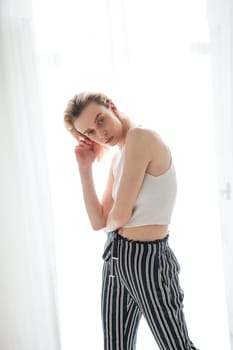 portrait of a beautiful blonde woman in striped pants on a white background