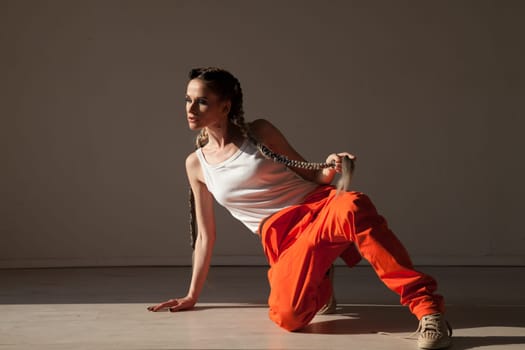 Portrait of a beautiful fashionable woman with braids dancing to music