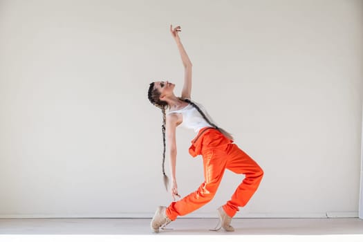 Portrait of a beautiful fashionable woman with braids dancing to music