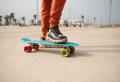 Skateboarding legs. Close-up teenager legs on skateboard, skateboarding on a skatepark playground outdoors. People. Lifestyle. Leisure activity. Kids entertainment concept. Extreme sport. Childhood